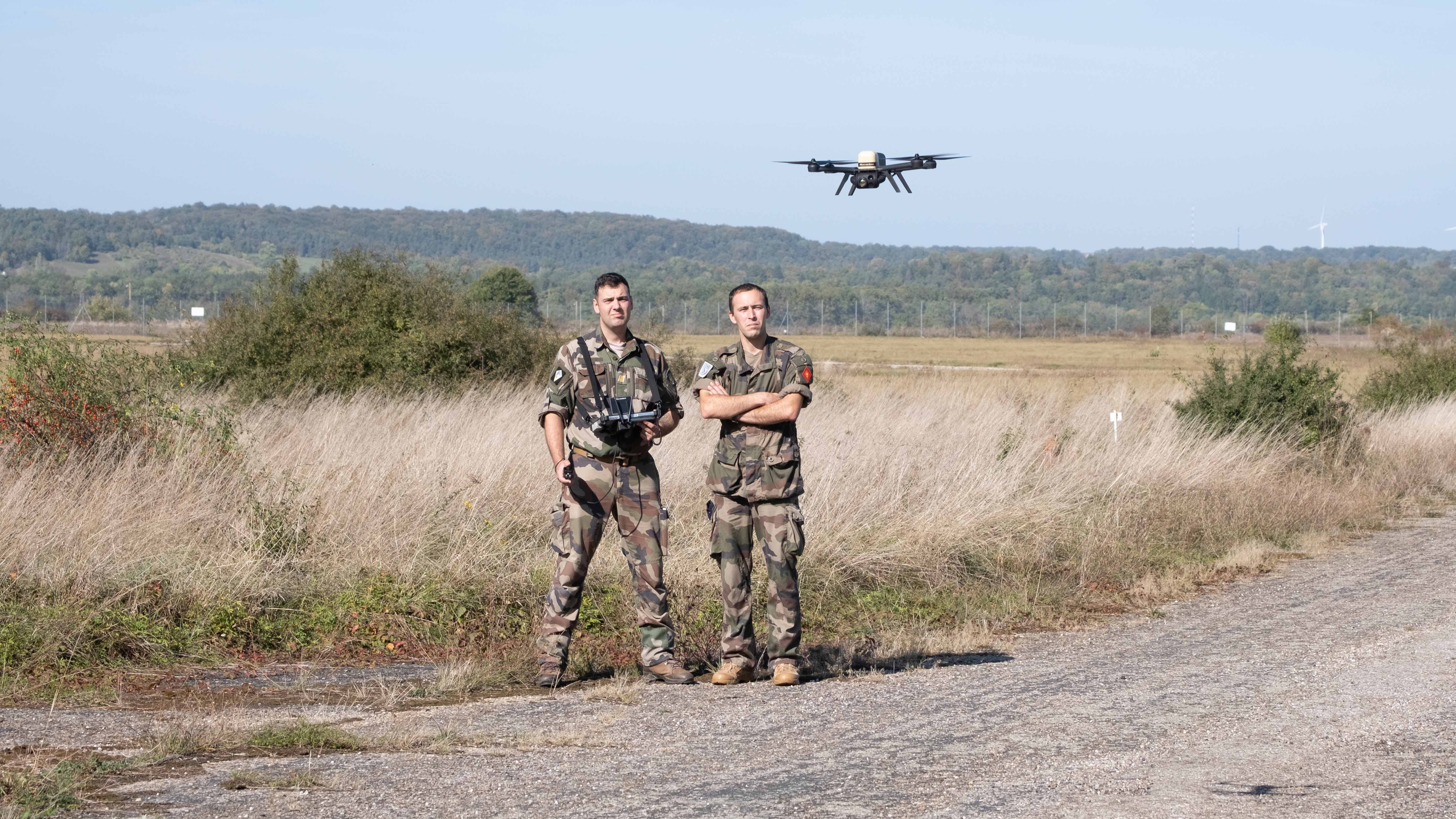 Un stagiare pilote son drone, supervisé par son instructeur.