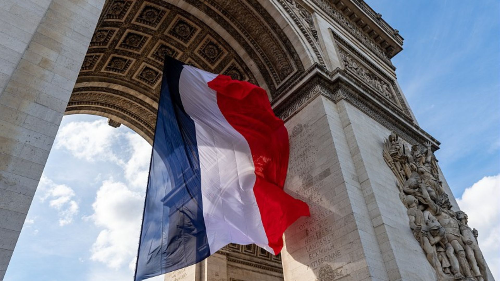 Le drapeau français flottant sous l'Arc de Triomphe.