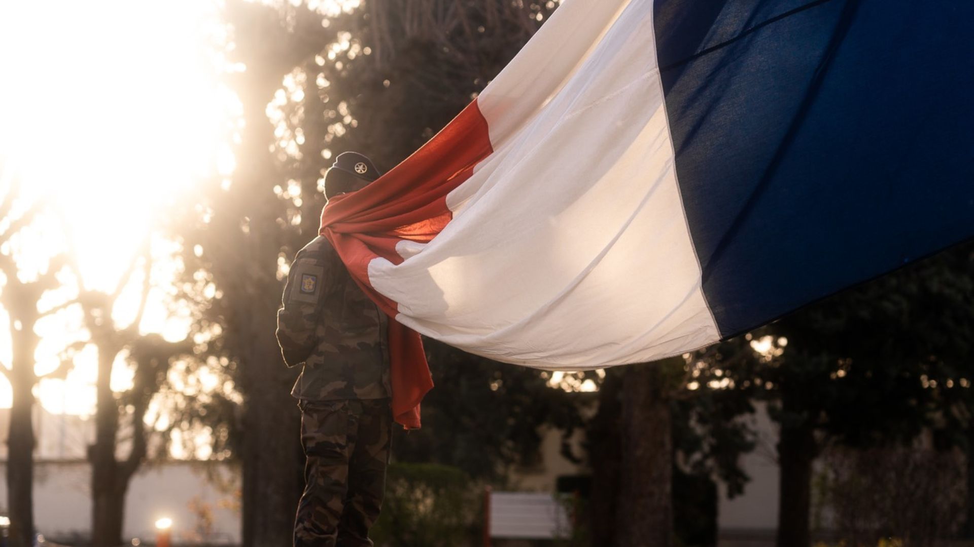 Un soldat s'apprête à hisser le drapeau français pour la montée des couleurs.