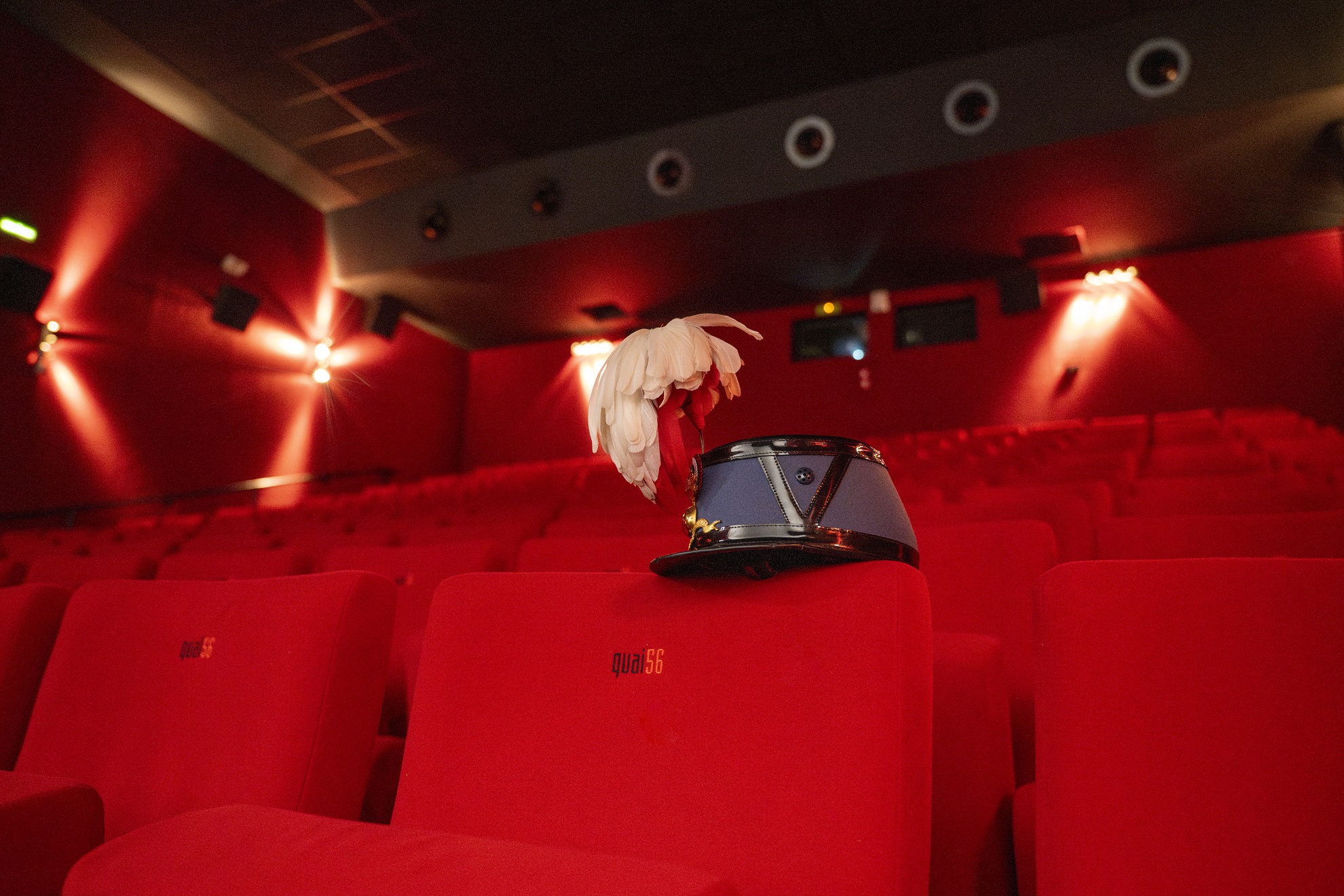 Un Caosar posé sur le dos d'un fauteuil dans une salle de cinéma.